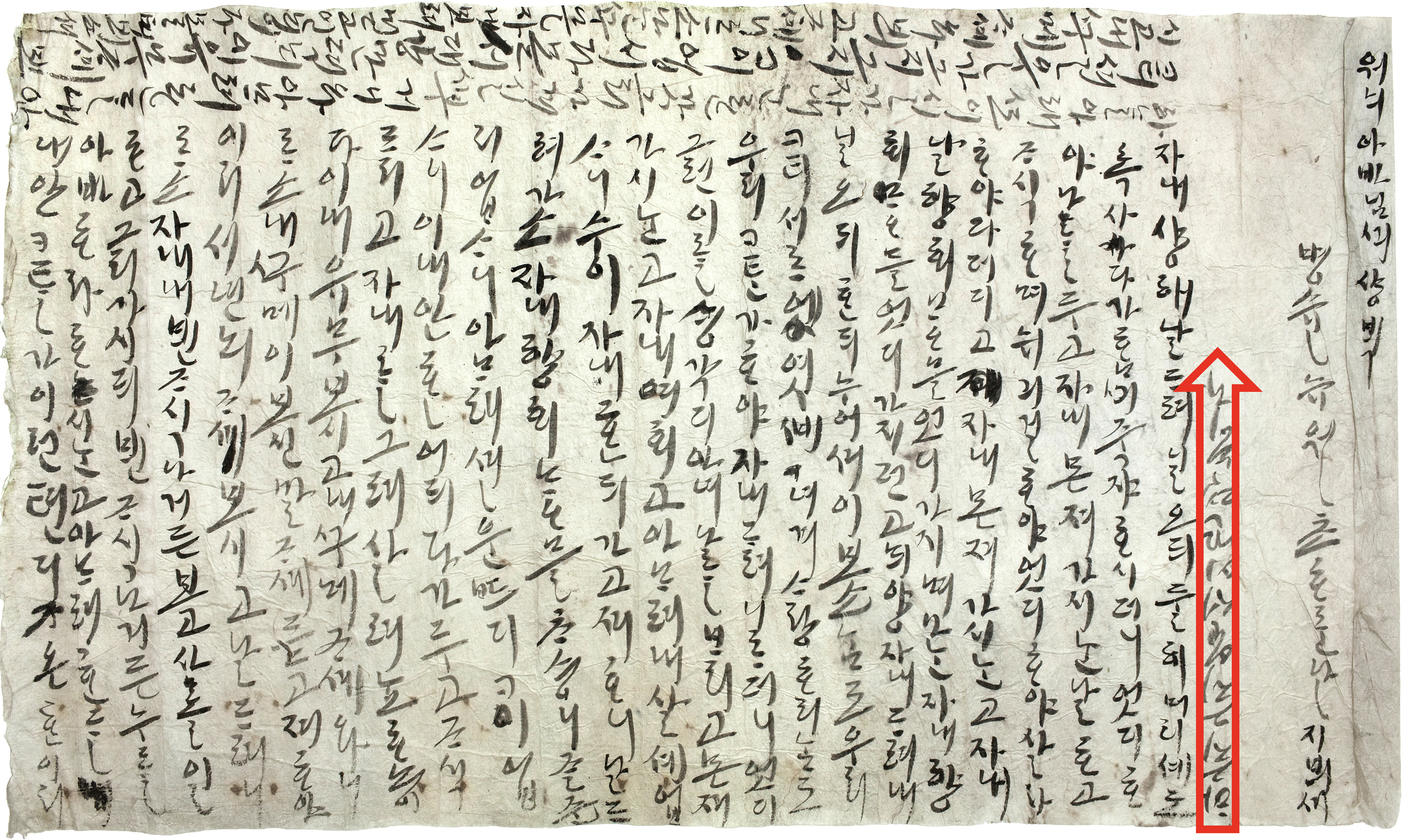 A handwritten letter in vernacular Korean on greenish-gray paper, with text written in three different directions. One narrow arrow highlights the single line written upside down and meant to be read from bottom to top.