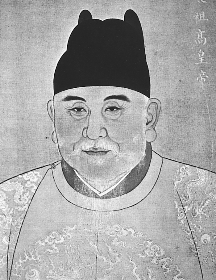 A portrait of an older man with a white mustache wearing a black hat and an embroidered robe.