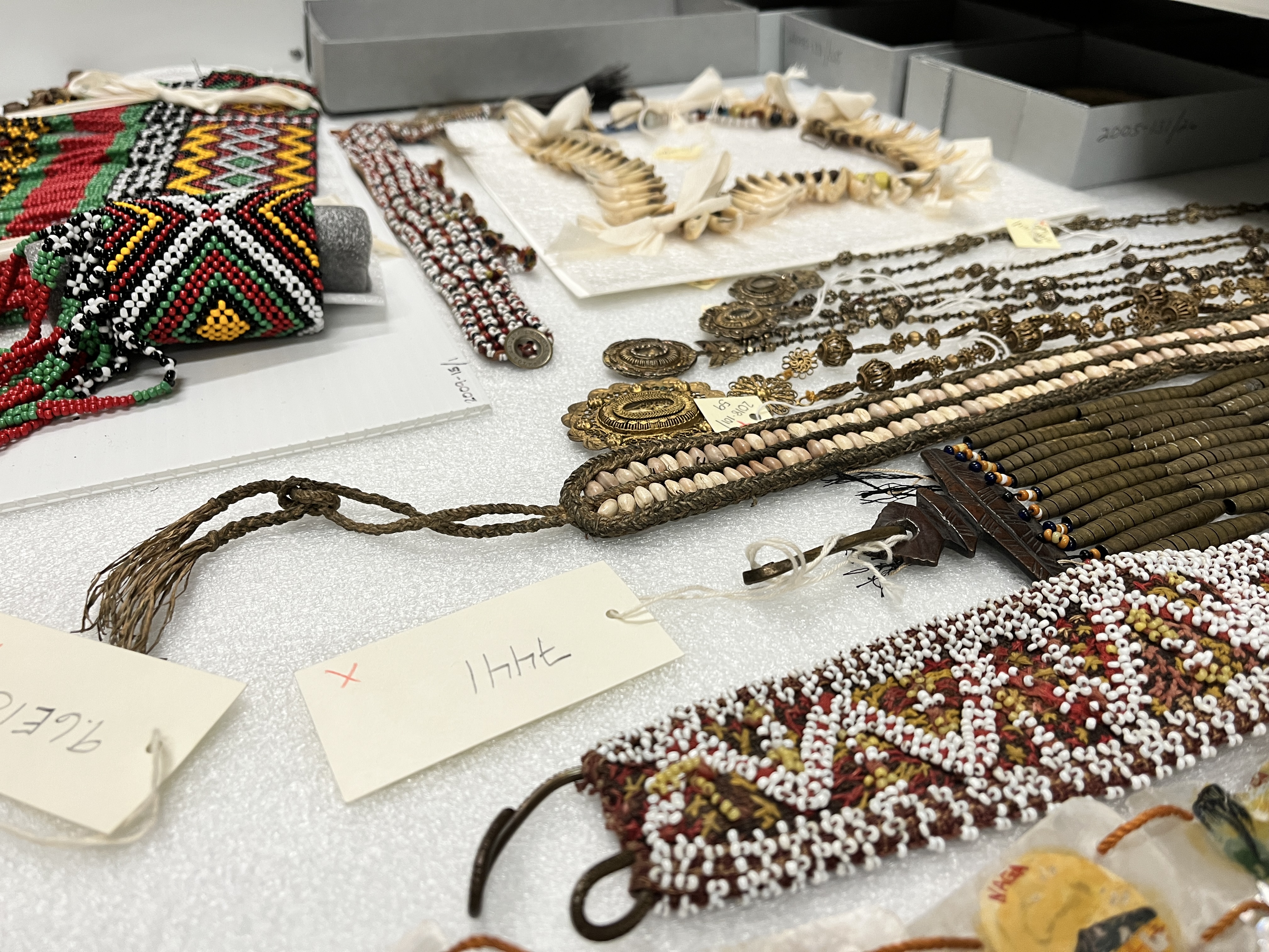 A variety of Philippine jewelry made out of red, white, and black beads, dog's teeth, shell, and gold filigree.