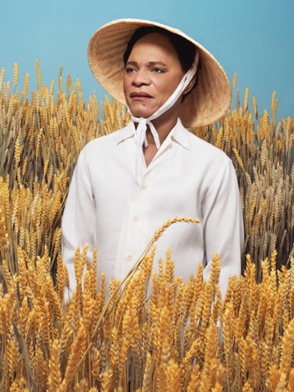 A person in a straw hat in a field of wheat

Description automatically generated