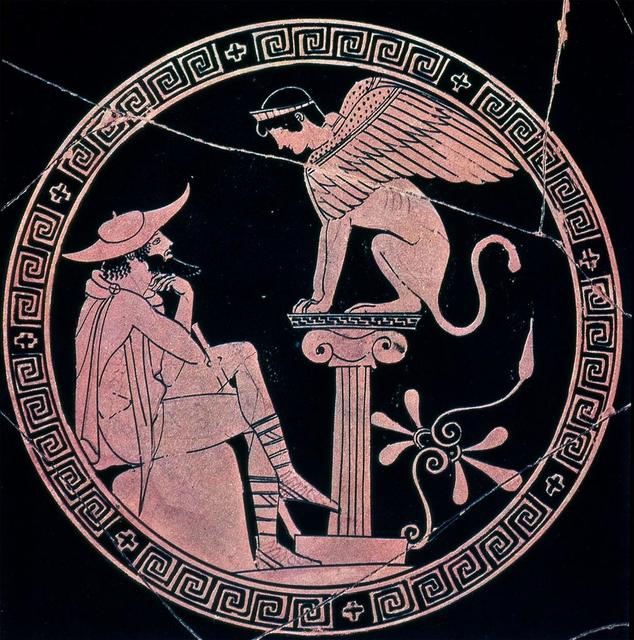 On this Greek vase, the sphinx is depicted as a creature with a lion’s body, bird’s wings, and human woman’s head (wearing a tiara). She sits perched on a small Ionic column on the right and looks down at Oedipus, on the left, who is seated. Oedipus, depicted as a bearded adult man, wears a short cloak and a petasus on his head. He crosses his left leg over his right (with his staff propped between his legs) and crosses his arms, with his left hand placed contemplatively beneath his chin.