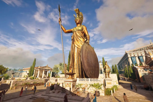 A large bronze statue of the goddess Athena from the multi-platform game Assassin's Creed: Odyssey. The statue  wears a golden chest plate and helmet. In one hand she holds a gold tipped spear and in the other balances a circular shield on the ground. 